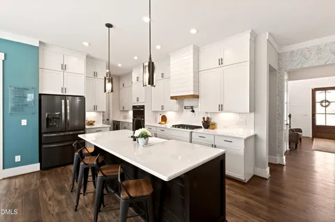 a kitchen with a sink a center island stainless steel appliances and cabinets