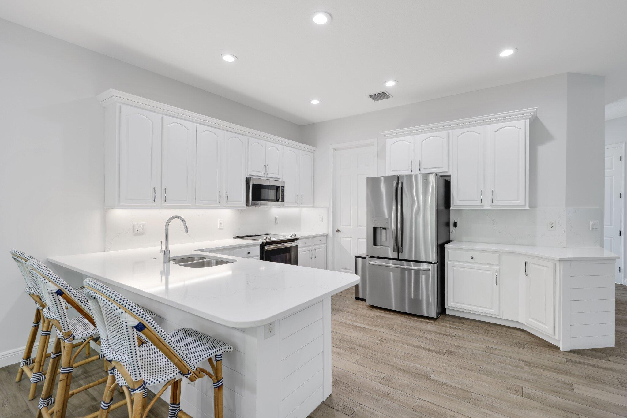 140 Mangrove Bay Way, Unit 140 Jupiter, FL 33477 - Photo 15 of 33 a kitchen with refrigerator cabinets and wooden floor