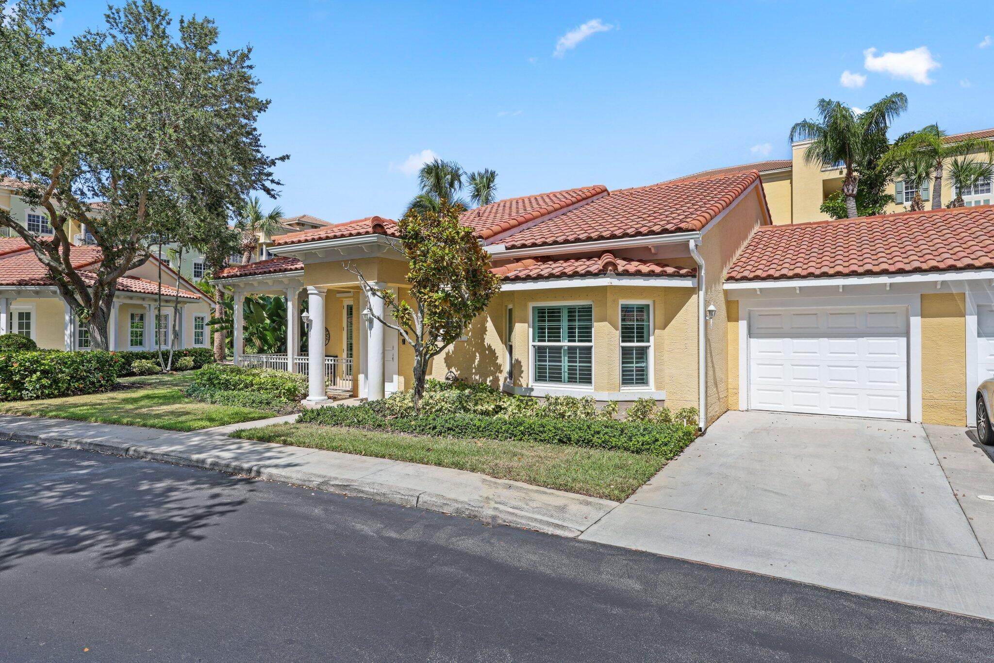 140 Mangrove Bay Way, Unit 140 Jupiter, FL 33477 - Photo 2 of 33 front view of a house with a yard