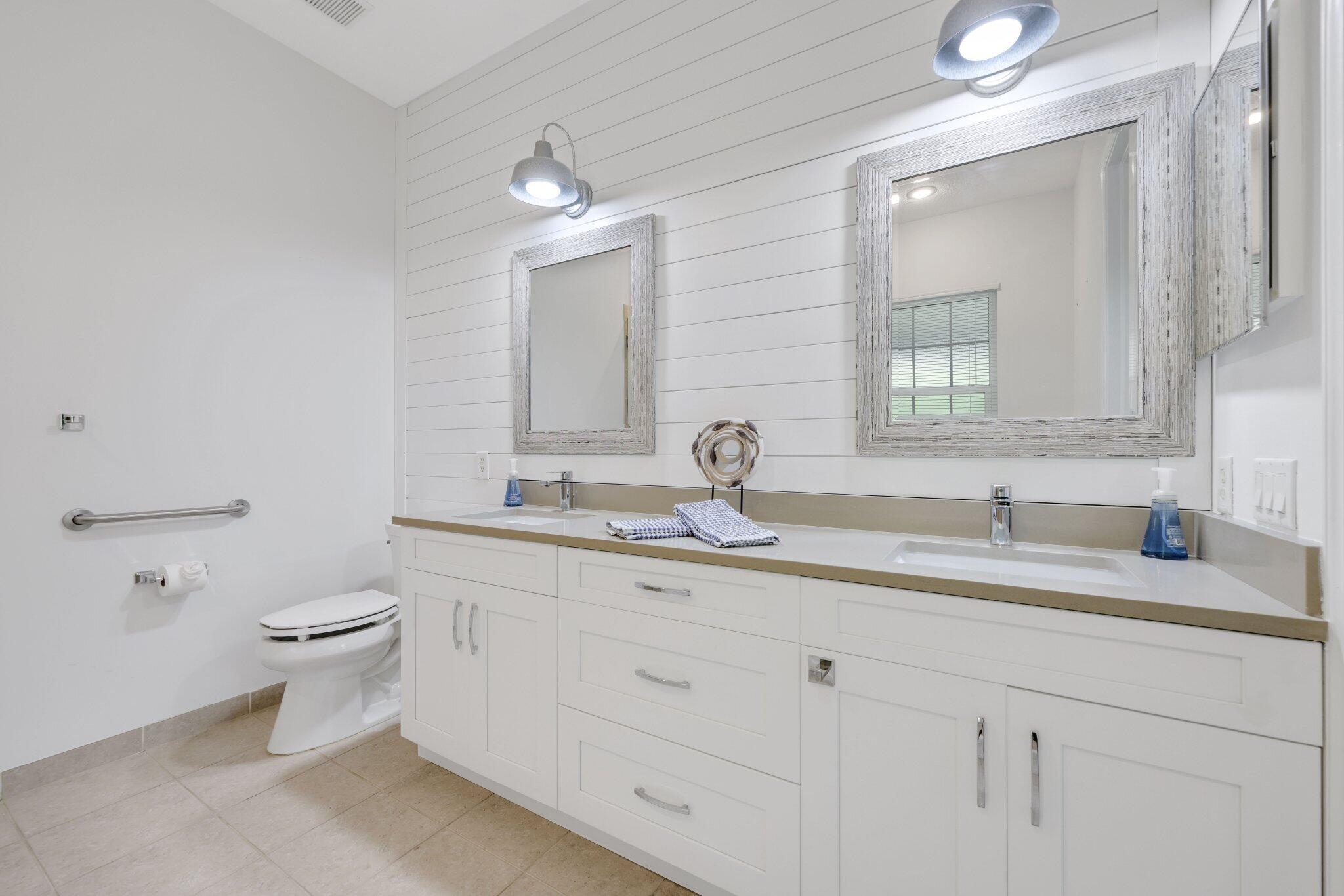 140 Mangrove Bay Way, Unit 140 Jupiter, FL 33477 - Photo 23 of 33 a bathroom with a toilet sink and mirror