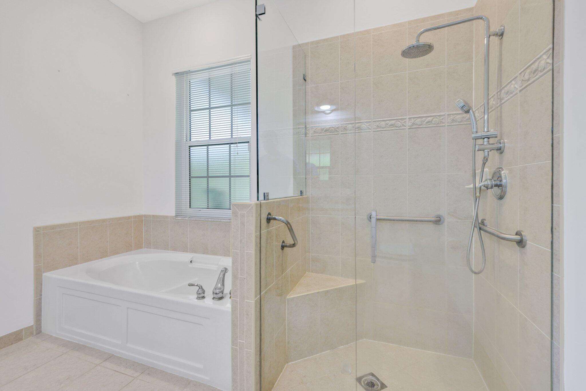 140 Mangrove Bay Way, Unit 140 Jupiter, FL 33477 - Photo 24 of 33 a bathroom with a bathtub and shower