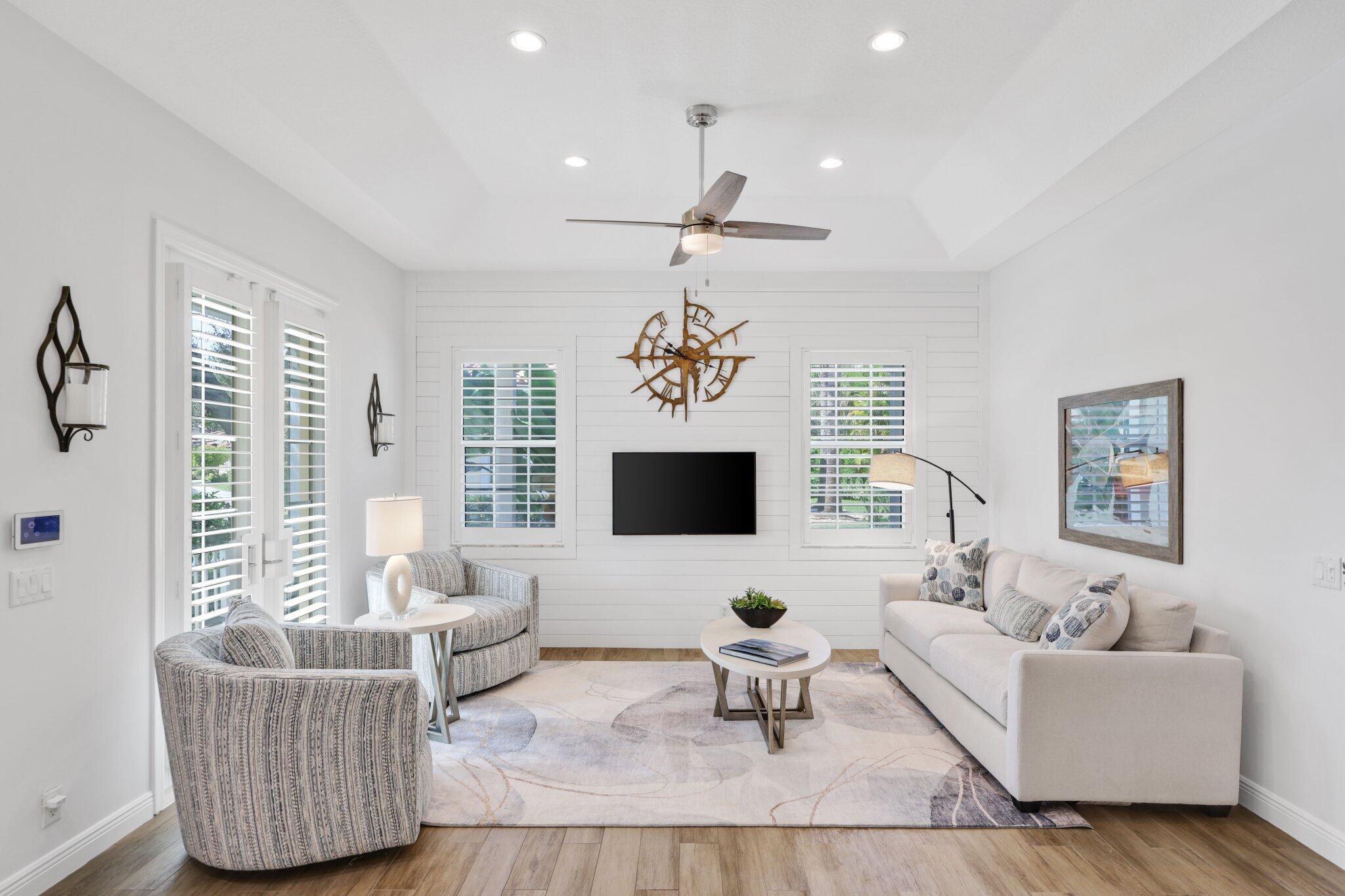 140 Mangrove Bay Way, Unit 140 Jupiter, FL 33477 - Photo 7 of 33 a living room with furniture a flat screen tv and a window