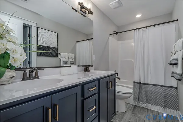 a bathroom with a granite countertop sink toilet a mirror a vanity and shower