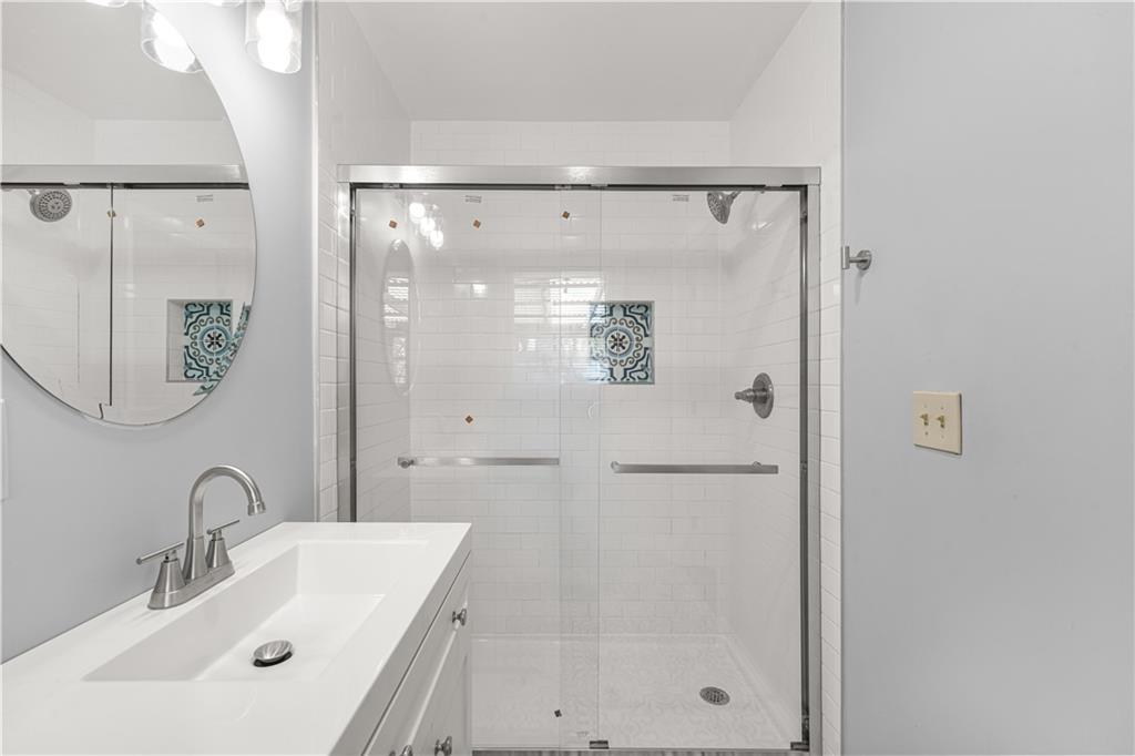 626 Grayson Parkway Grayson, GA 30017 - Photo 21 of 27 a bathroom with a shower a mirror and a sink
