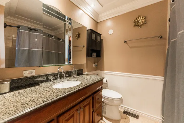 a bathroom with a granite countertop sink toilet and shower