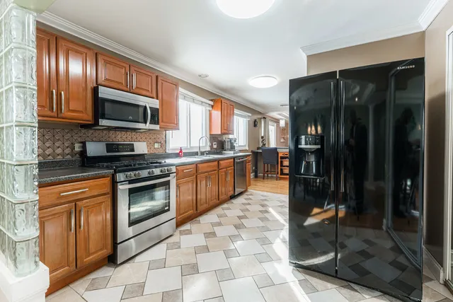 a kitchen with stainless steel appliances granite countertop a stove a sink and a microwave