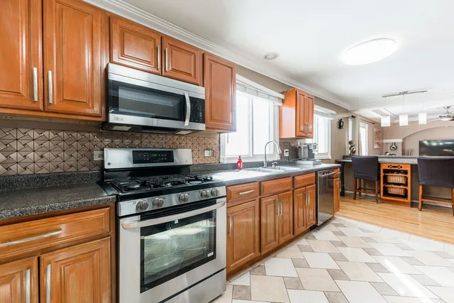 a kitchen with stainless steel appliances granite countertop a stove microwave and sink