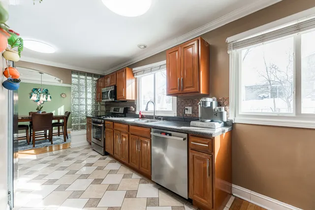 a kitchen with stainless steel appliances granite countertop a stove a sink and a microwave