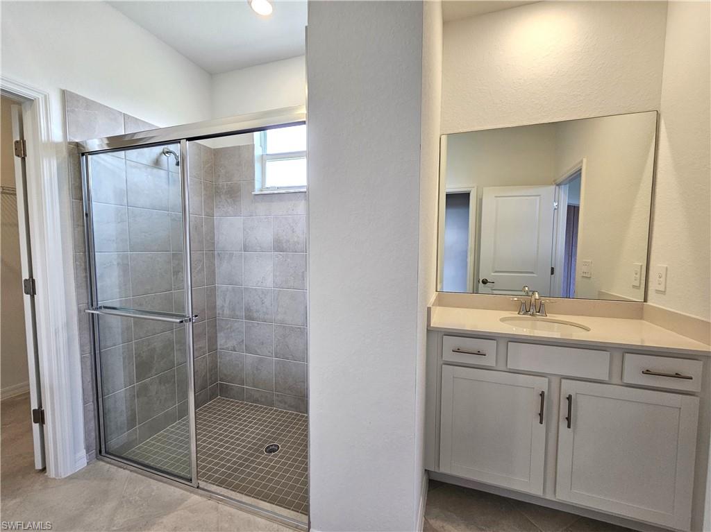 2168 Dragonfruit Way Naples, FL 34120 - Photo 14 of 27 a bathroom with a shower sink and mirror