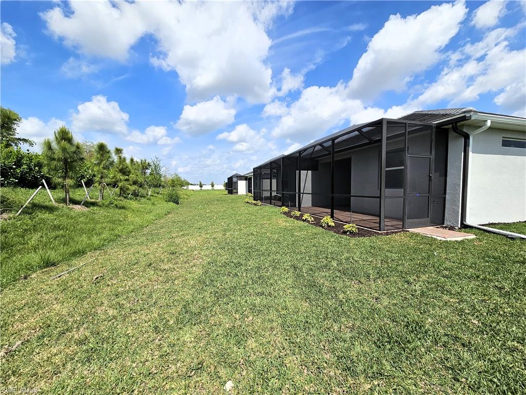 2168 Dragonfruit Way Naples, FL 34120 - Photo 20 of 27 a backyard of a house with lots of green space