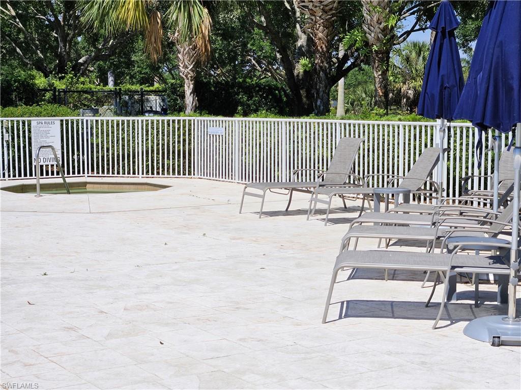 2168 Dragonfruit Way Naples, FL 34120 - Photo 24 of 27 a view of a deck with a floor to ceiling window and wooden fence