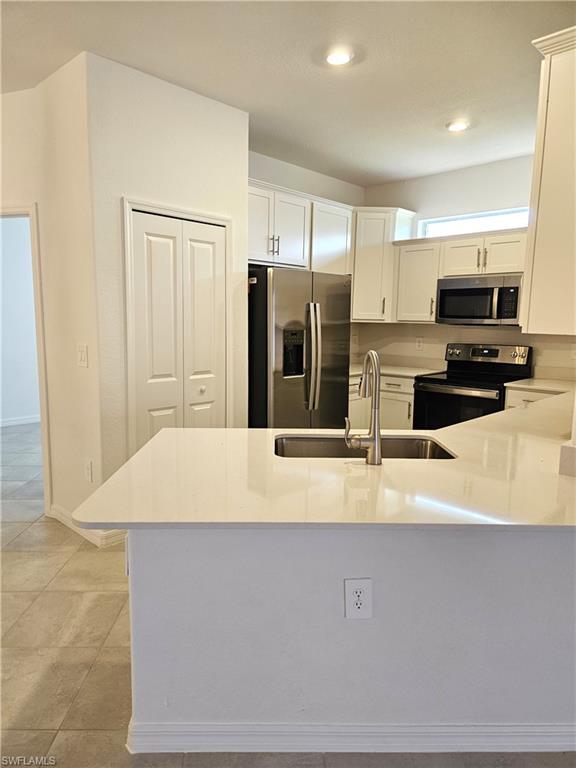 2168 Dragonfruit Way Naples, FL 34120 - Photo 7 of 27 a large kitchen with stainless steel appliances a refrigerator sink and microwave