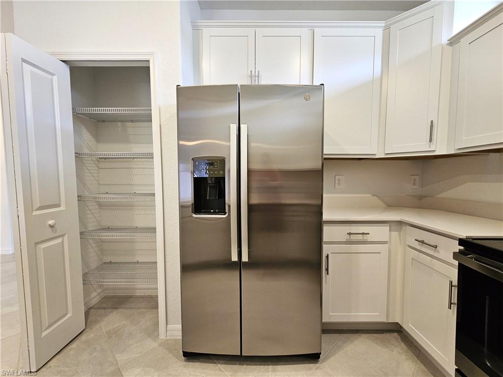 2168 Dragonfruit Way Naples, FL 34120 - Photo 9 of 27 a kitchen with cabinets and stainless steel appliances
