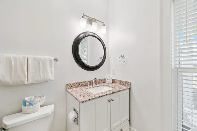 a bathroom with a sink vanity mirror and toilet