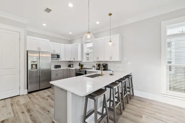 a kitchen with a dining table chairs and white cabinets