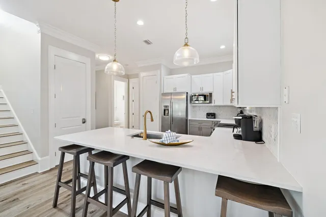 a kitchen that has a lot of white cabinets and couches