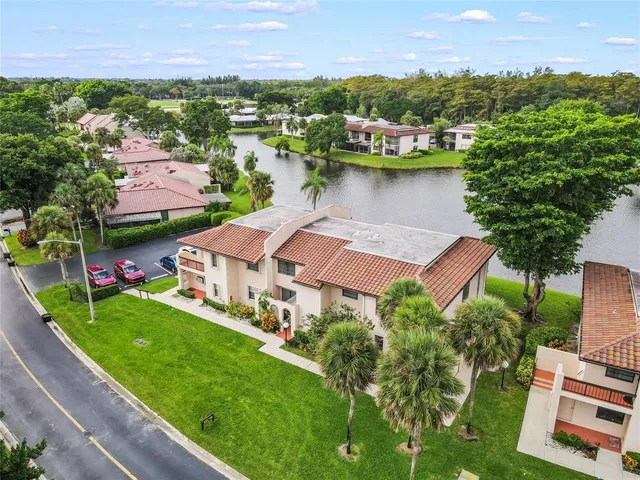 an aerial view of residential houses with outdoor space and lake view