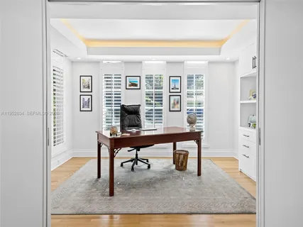 a large white kitchen with lots of counter space wooden floor and appliances