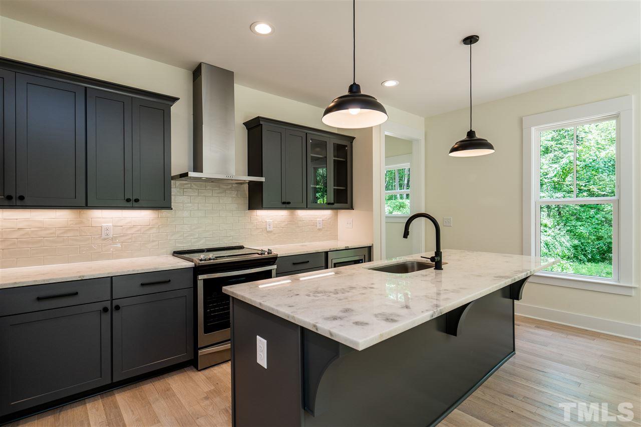 1700 Evergreen Avenue Raleigh, NC 27603 - Photo 12 of 27 a kitchen with a sink a counter space appliances and cabinets
