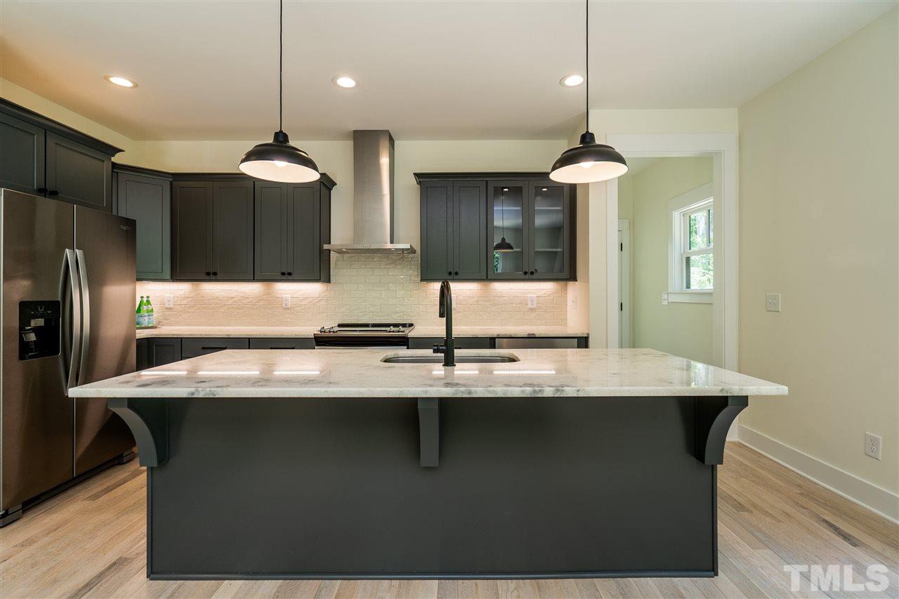 1700 Evergreen Avenue Raleigh, NC 27603 - Photo 13 of 27 a kitchen with kitchen island stainless steel appliances a sink and a refrigerator