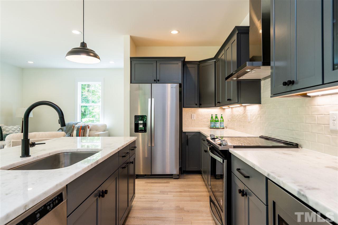 1700 Evergreen Avenue Raleigh, NC 27603 - Photo 15 of 27 a kitchen with stainless steel appliances granite countertop a sink a stove and a refrigerator
