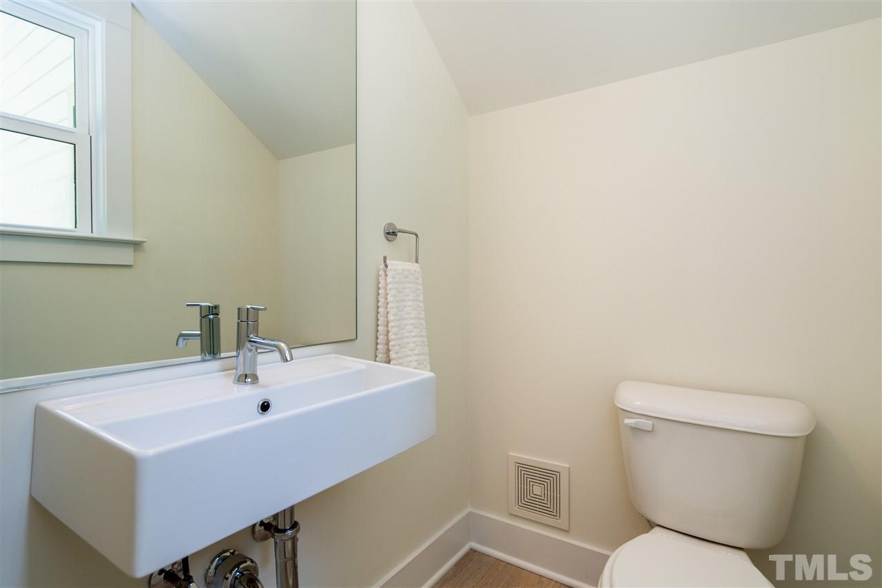 1700 Evergreen Avenue Raleigh, NC 27603 - Photo 17 of 27 a bathroom with a sink a toilet and a mirror
