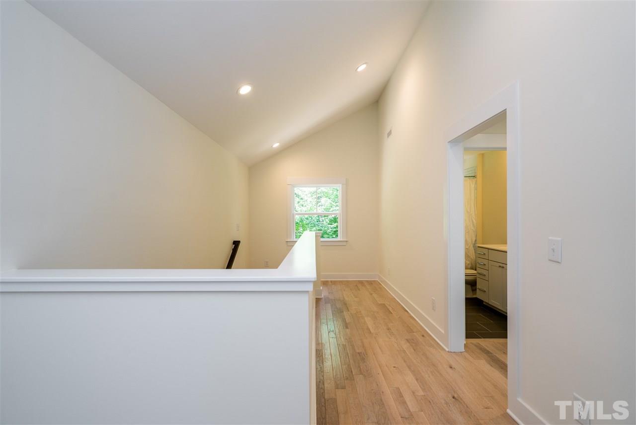 1700 Evergreen Avenue Raleigh, NC 27603 - Photo 22 of 27 a view of a hallway to an empty room with wooden floor and a window
