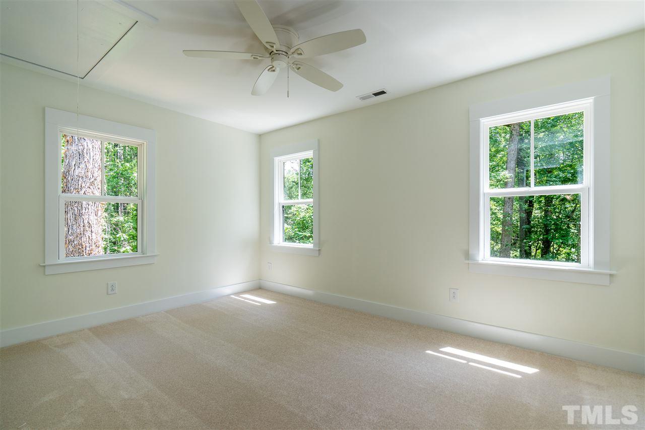 1700 Evergreen Avenue Raleigh, NC 27603 - Photo 23 of 27 en empty room with windows and chandelier fan