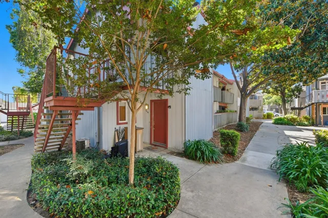 a front view of a house with a yard and trees