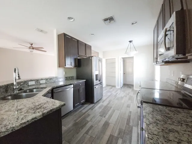 a kitchen with stainless steel appliances granite countertop a sink stove and refrigerator