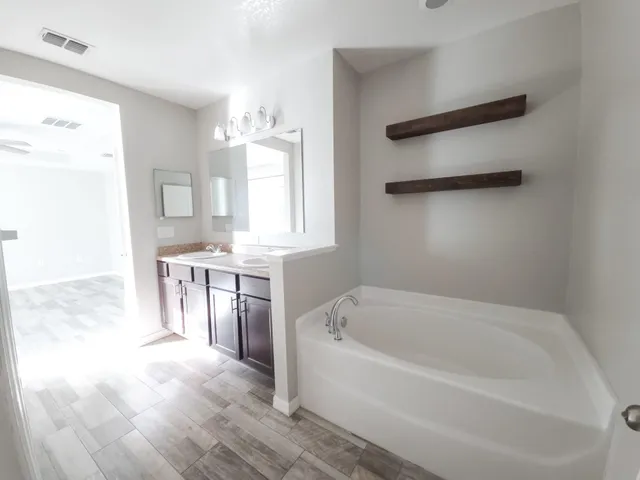 a spacious bathroom with a bathtub and a sink
