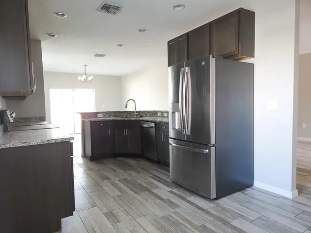 a kitchen with stainless steel appliances granite countertop a refrigerator and a sink