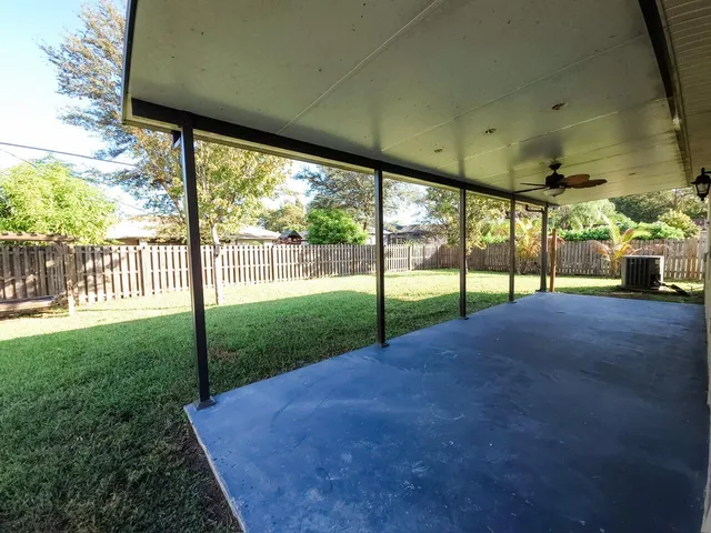 a view of a yard with porch and wooden fence