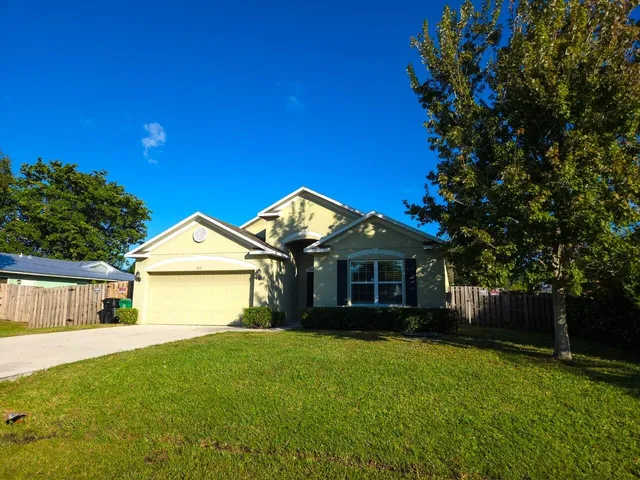 a front view of a house with a garden and yard