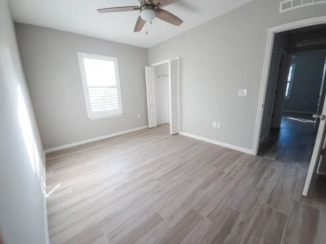 a view of a livingroom with wooden floor and a ceiling fan