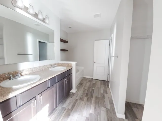 a spacious bathroom with a granite countertop sink toilet and a mirror
