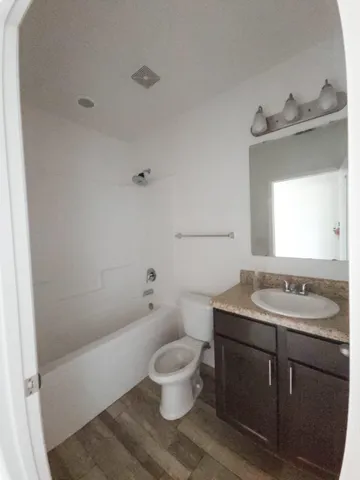a bathroom with a sink toilet vanity and tub