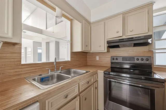 a kitchen with stainless steel appliances granite countertop a sink stove and cabinets