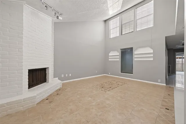 a view of an empty room with a fireplace and a window