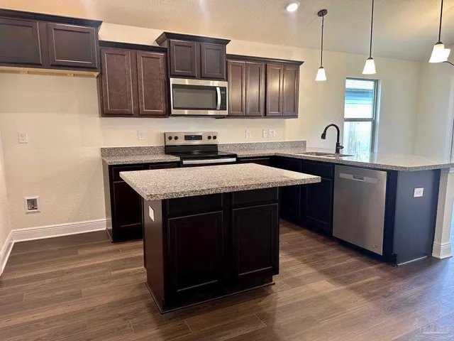 a kitchen with a sink a microwave a stove and refrigerator