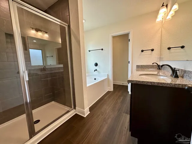 a en suite bathroom with a granite countertop sink and mirror