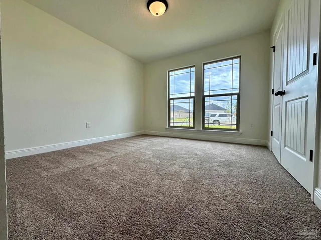 an empty room with windows and closet