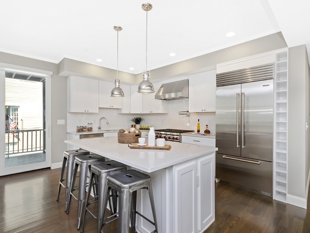 260 Gold Street, Unit 1 Boston, MA 02127 - Photo 4 of 16 a kitchen with kitchen island a stove a table and chairs in it