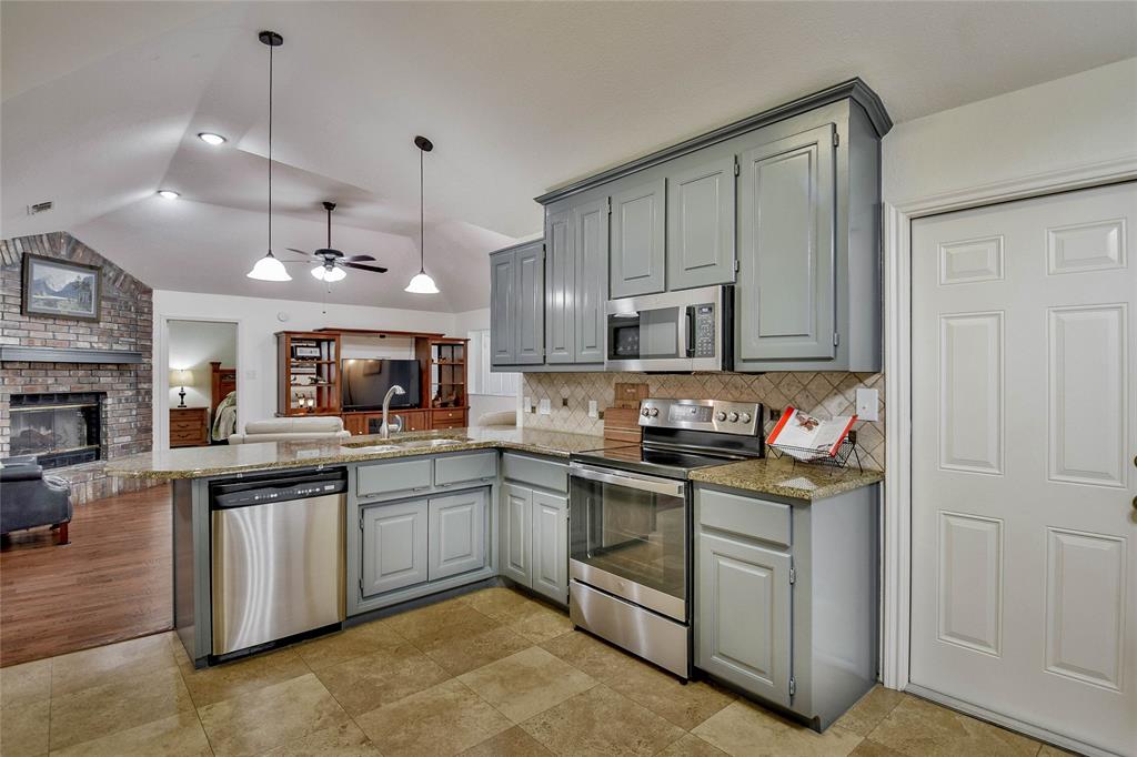 9100 Bellechase Road Granbury, TX 76049 - Photo 37 of 37 a kitchen with stainless steel appliances granite countertop a stove a sink and a refrigerator