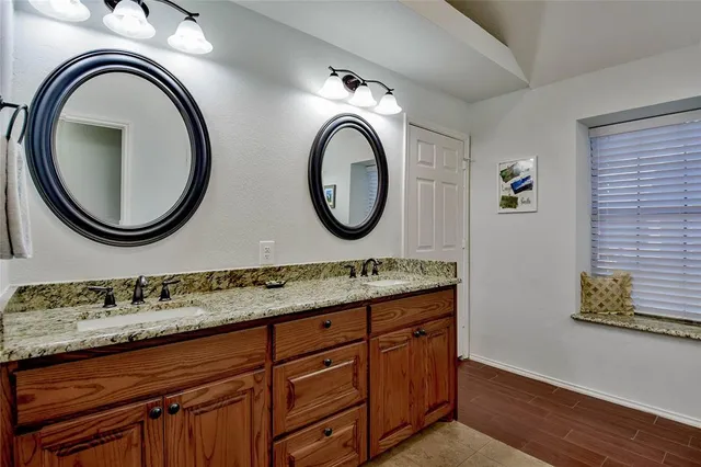 a bathroom with a granite countertop sink and a mirror