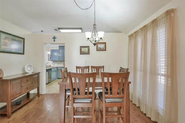 a view of a dining room with furniture wooden floor and chandelier