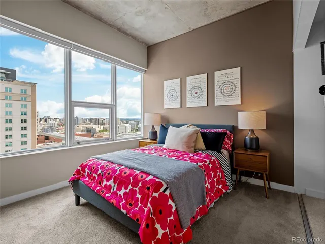 a bedroom with a bed and a large window