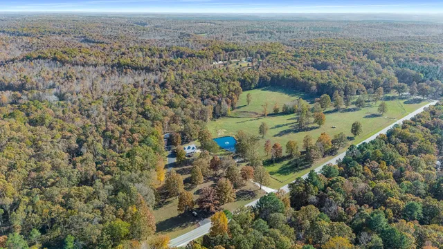 an aerial view of a house with a yard and lake view