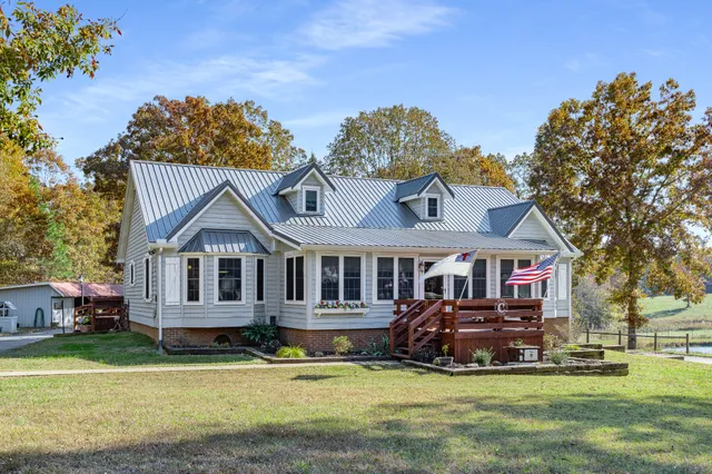a front view of a house with a garden and trees