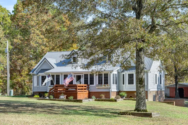 a front view of a house with a garden and trees